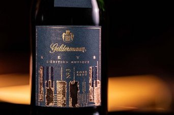 Eine elegante Weinflasche mit einem kunstvollen Etikett, das goldene und schwarze Designelemente kombiniert.