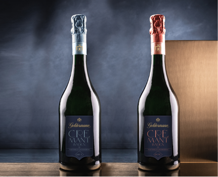 Zwei Flaschen Crémant aus Baden stehen nebeneinander, eine mit blauer und die andere mit roter Kapsel, auf einem eleganten Hintergrund.