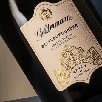 Das Etikett der Geldermann-Flasche zeigt den Namen Weißburgunder und die Bezeichnung 'Extra Brut' in goldener Schrift.