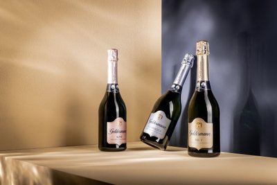 Arrangement von drei Geldermann Les Premiers-Sektflaschen vor blau-goldenem Hintergrund.