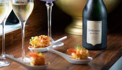 Ein elegantes Arrangement aus Sekt und feinen Garnelenhäppchen, das eine einladende und luxuriöse Stimmung vermittelt.