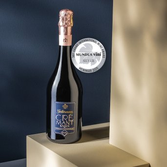 Ein hochwertiger Crémant Baden in einer schlanken Flasche, dekoriert mit einem roséfarbenen Korken, präsentiert sich auf einem minimalistischen Hintergrund.