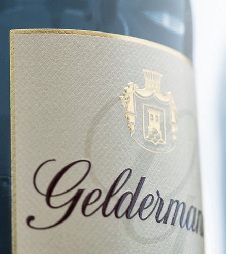 Das Etikett einer Weinflasche zeigt den Namen 'Gelderman' in eleganter Schrift auf einem strukturierten Hintergrund.
