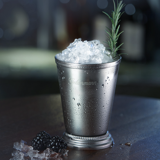 Der silberne Becher, gefüllt mit zerstoßenem Eis, steht auf einem Tisch, während die Tropfen auf der Oberfläche glänzen.