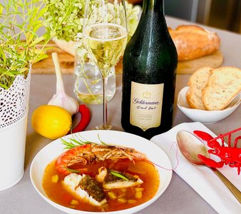 Ein elegantes Gericht mit Meeresfrüchten, serviert in einer weißen Schüssel, umgeben von frischen Zutaten und einem Glas Sekt.