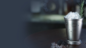 Der silberne Becher, gefüllt mit zerstoßenem Eis, steht auf einem Tisch, während die Tropfen auf der Oberfläche glänzen.