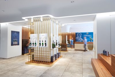 Ein geschmackvoll eingerichteter Weinshop mit goldenen Akzenten und einer einladenden Atmosphäre für Kunden.