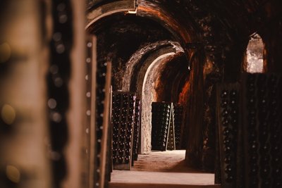 Geldermann-Weinkeller mit gewölbten Decken und Reihen von Sekt-Flaschen auf Holzregalen