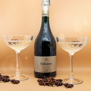 Die Flasche Geldermann Sekt ist in der Mitte platziert, flankiert von zwei Gläsern, die mit Sternanis dekoriert sind.