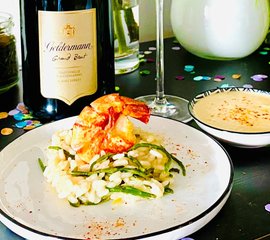 Ein Teller mit cremigem Risotto, garniert mit einer großen, gebratenen Garnele und frischen grünen Bohnen.