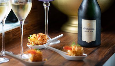Ein elegantes Arrangement aus Sekt und feinen Garnelenhäppchen, das eine einladende und luxuriöse Stimmung vermittelt.