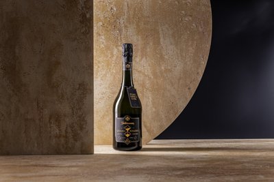 Ein stilvoller Sekt in einer dunklen Umgebung, umgeben von sanften, erdigen Tönen, strahlt Raffinesse aus.