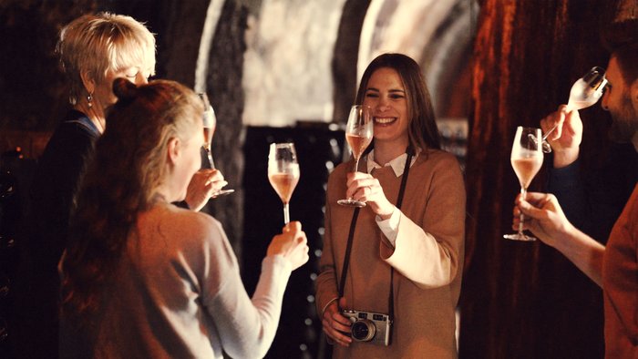 Die Gruppe genießt einen festlichen Moment, während sie mit Gläsern anstoßen und die Freude des Zusammenseins teilen.