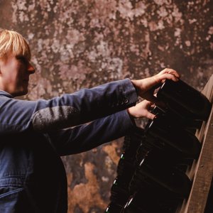 Déborah Ruffing Tabbone dreht Flaschen im Holzregal im Geldermann-Weinkeller