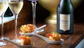 Ein elegantes Arrangement aus Sekt und feinen Garnelenhäppchen, das eine einladende und luxuriöse Stimmung vermittelt.